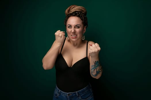 A woman wearing a black shirt and jeans is striking a pose for a photograph. She is confidently standing and smiling at the camera, showcasing her casual yet stylish outfit.