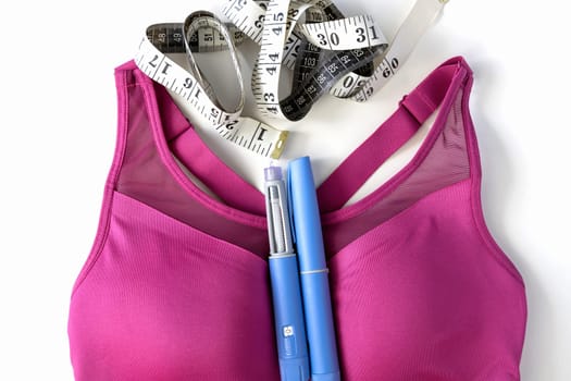 Concept of losing weight with the diabetes drug Ozempic. Layout with sports top and Ozempic syringe pen. High quality photo