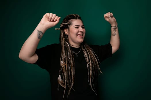 A woman with dreadlocks is wearing a black shirt. Her hair is styled in long, thick dreadlocks, and she is dressed in a plain black shirt. The focus is on her unique hairstyle and choice of clothing.