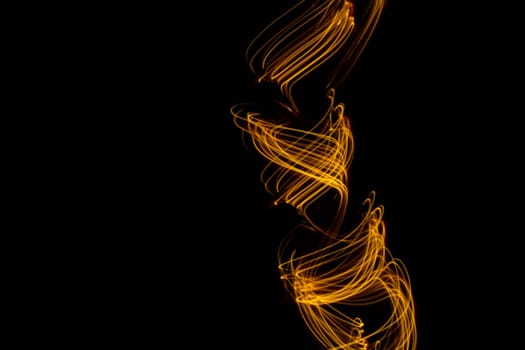 Long exposure light painting photography, curvy lines of vibrant neon metallic yellow gold against a black background. High quality photo