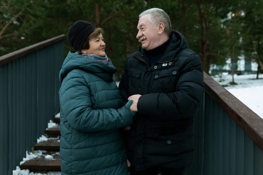 Happy elderly couple walking in the park in winter.
