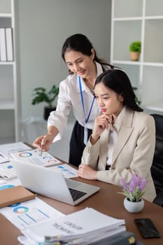 Two business professionals engaged in teamwork, planning, and analysis discussion in a modern office setting.