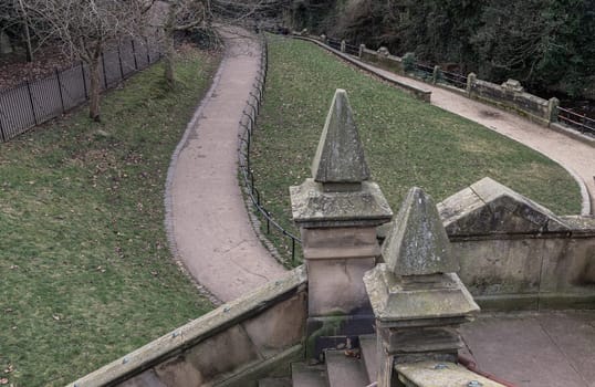 Edinburgh, Scotland - Jan 16, 2024 - A view of St.Bernards Bridge and Elongated park on the waterfront of The Water of Leith near Stockbridge and Dean Village in the city of Edinburgh. The peaceful scenery, Space for text, Selective focus.