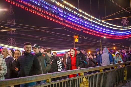 crowd of Russian people at road on the hill and bridge are watching fireworks in a night sky in Tula, Russia - May 9, 2021