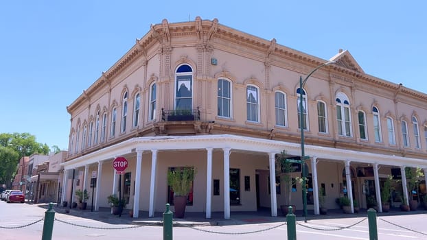 Santa Fe, New Mexico, USA-June 11, 2024-Slow motion-The main square of a historic downtown area featuring traditional adobe buildings, lively shops, and pedestrians enjoying a sunny day.