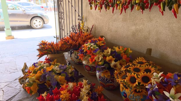 Santa Fe, New Mexico, USA-June 11, 2024-Slow motion-A vibrant outdoor market showcasing an array of colorful ceramics, pottery, and handcrafted items. Shoppers explore the unique local crafts under a sunny sky, surrounded by traditional adobe architecture.