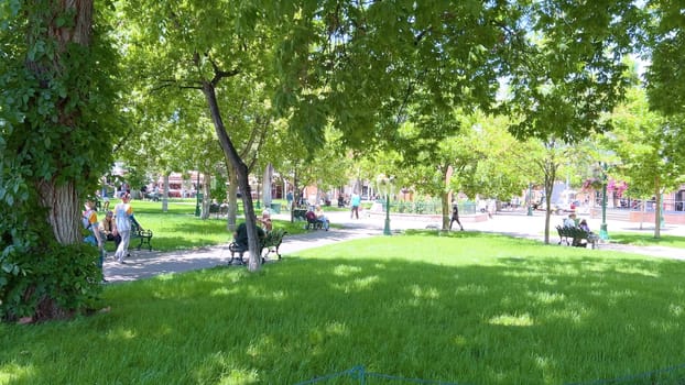 Santa Fe, New Mexico, USA-June 11, 2024-Slow motion-The main square of a historic downtown area featuring traditional adobe buildings, lively shops, and pedestrians enjoying a sunny day.