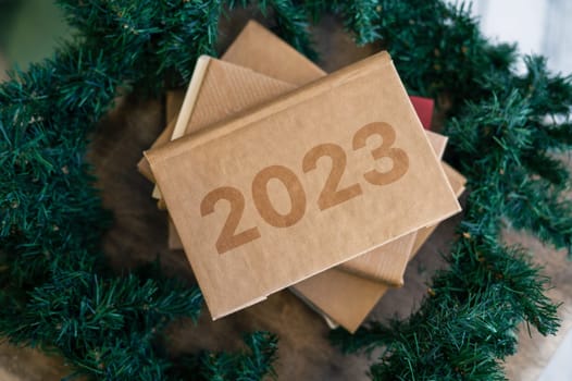 Book or handmade notebook with 2023 title at the chtistmas tree