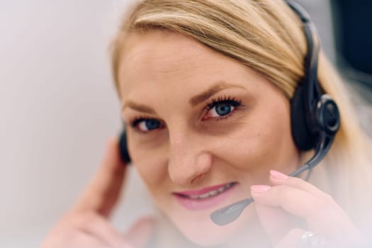 Friendly call center agent answering incoming calls with a headset, providing customer service remotely. Happy woman using her excellent communication skills to resolves customer issues.