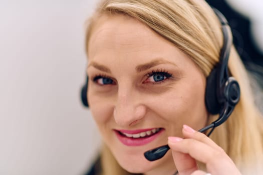 Friendly call center agent answering incoming calls with a headset, providing customer service remotely. Happy woman using her excellent communication skills to resolves customer issues.