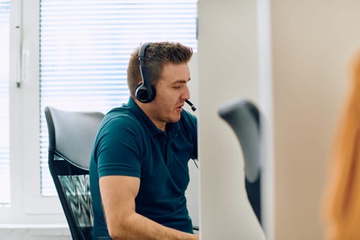 A detailed close-up captures a focused customer support representative wearing a headset while providing assistance in a call center setting.