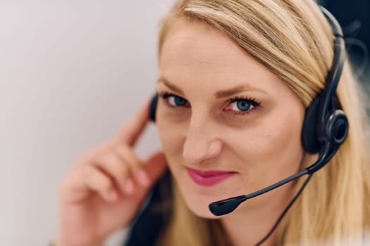 Friendly call center agent answering incoming calls with a headset, providing customer service remotely. Happy woman using her excellent communication skills to resolves customer issues.