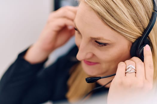 Friendly call center agent answering incoming calls with a headset, providing customer service remotely. Happy woman using her excellent communication skills to resolves customer issues.