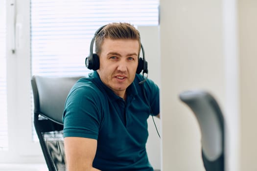 A detailed close-up captures a focused customer support representative wearing a headset while providing assistance in a call center setting.