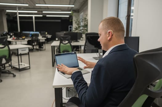 Caucasian deaf man communicates in sign language on laptop in office