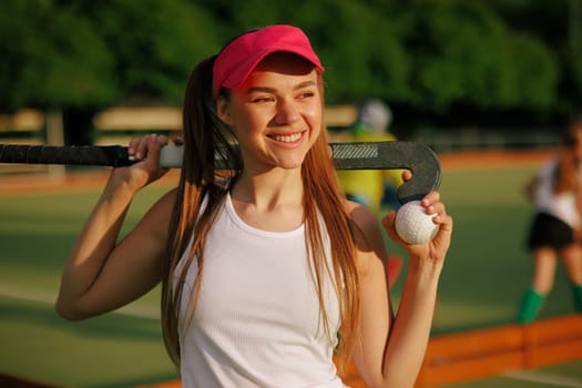 girl hockey player plays field hockey on a sunny day, female hockey player hits the ball with a stick, field hockey concept