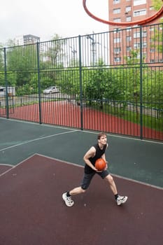 Caucasian man playing basketball outdoors. Vertical photo