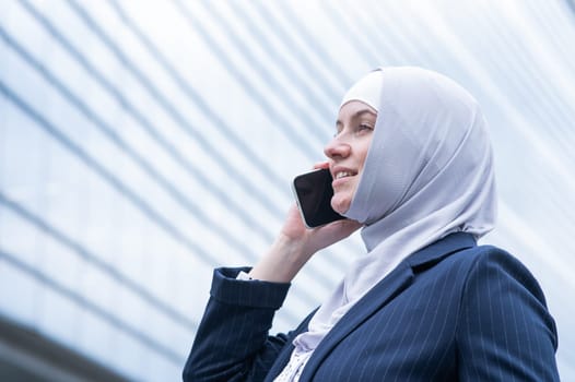 Business woman in hijab and suit talking on smartphone