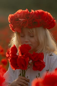 A young girl wearing a red flower crown is surrounded by red flowers. She is holding a bouquet of red flowers in her hand