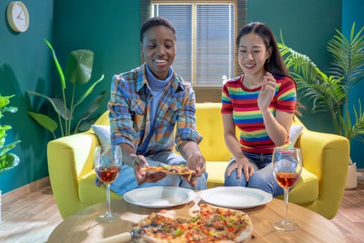Two female friends celebrating with pizza and wine. High quality photo