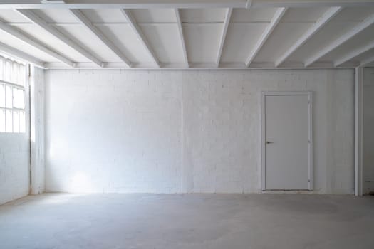 Empty industrial space with white walls and a door background with copy space for text. High quality photo