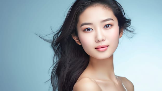 Portrait of a beautiful, sexy, smiling Asian woman with perfect skin, on a light blue background, banner. Advertising of cosmetic products, spa treatments, shampoos and hair care products, medicine, perfumes and cosmetology