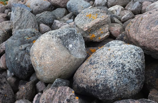 Huge boulders scattered randomly on the site of an old stone pier. Stones background and texture. Ainazi North Pier