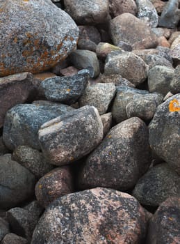Huge boulders scattered randomly on the site of an old stone pier. Stones background and texture. Ainazi North Pier