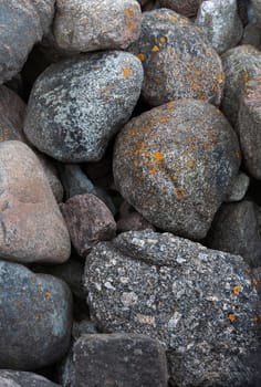 Huge boulders scattered randomly on the site of an old stone pier. Stones background and texture. Ainazi North Pier