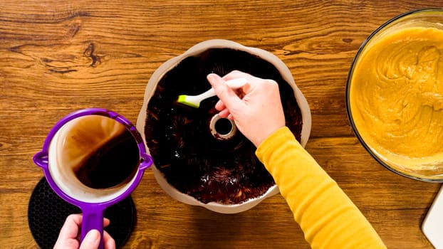 Flat lay. Carefully greasing a bundt cake pan in preparation for baking a delicious gingerbread bundt cake with caramel frosting.