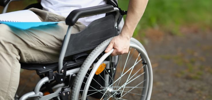 Man in wheelchair holds wheel with his hand. Rehabilitation of people with disabilities concept