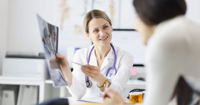 Female doctor shows patient an X-ray. Medical examination concept