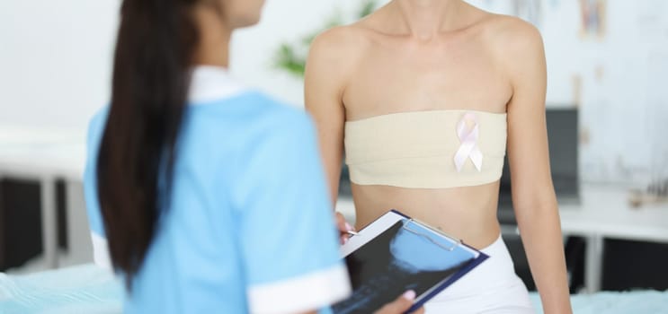 Doctor examines female mammary glands of patient. Oncology and female breast cancer concept