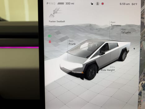 Denver, Colorado, USA-June 21, 2024-Close-up of a person hand interacting with the touchscreen interface of a Tesla Cybertruck. The screen displays various options and controls for the vehicle, including opening the frunk and tailgate. The high-tech interface highlights Tesla advanced features and user-friendly design.