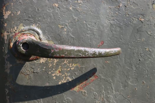 Old green rusty metal door handle, closeup of photo.