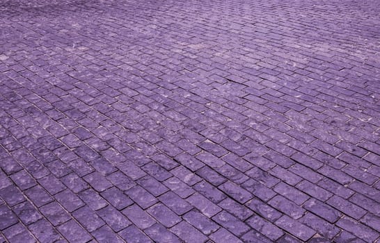 Vintage cobblestone pavement. Purple cobblestone background.