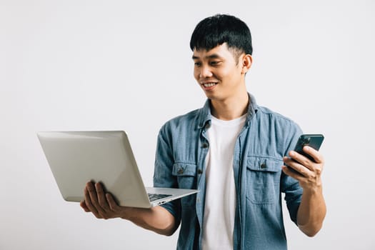 Portrait Asian smiling young man holding laptop and mobile phone studio isolated white background, Happy excited lifestyle businessman using computer and smartphone, modern technology and importance