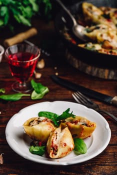 Baked jumbo shells pasta stuffed with ground beef, spinach and cheese on white plate