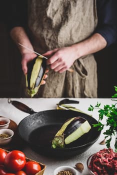 Preparing eggplants for baking and stuffing with ground beef and tomatoes