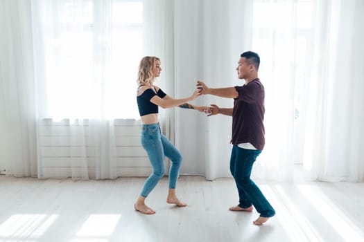 a man and woman dance in the hall of the latin bachata studio