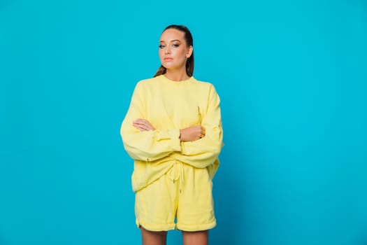 woman in a yellow suit stands on a blue background