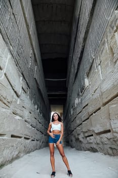 woman stands between large gray stone walls