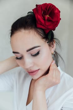 portrait of brunette woman with a red rose in her hair