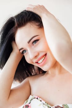 portrait of cheerful brunette woman on a light background