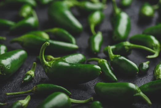 Raw Jalapeno Peppers on Black Concrete Backdrop