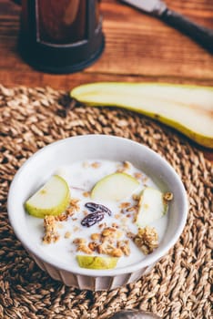 Homemade Granola with Fresh Pear and Milk in Vintage Bowl