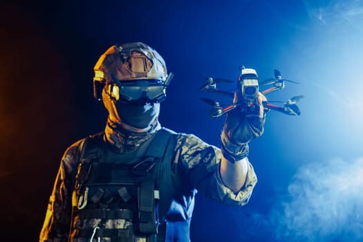 Soldier in gear holds drone against a red and blue smoky background, conveying intensity and military action