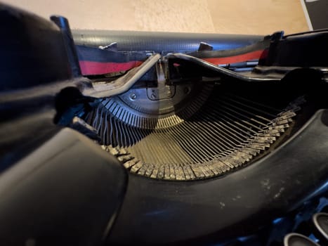 Close-up of an old typewriter's keyboard and internal striking mechanism in detail.