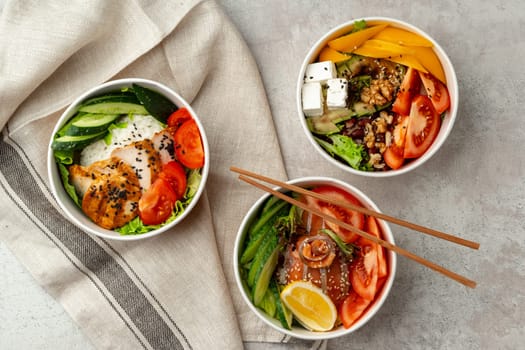 Beautiful composition with poke bowls on gray background with napkin close up