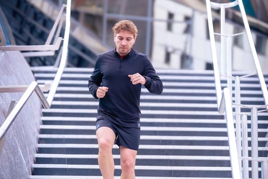 Man running down stairs,with bottle of water in hand doing his daily cardio and warm up exercise. Physical activity concept